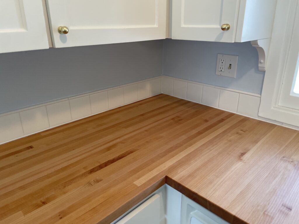 New cabinet door knobs, tile backsplash, butcher block countertop finished with Rubio Monocoat Oil Plus 2C Pure