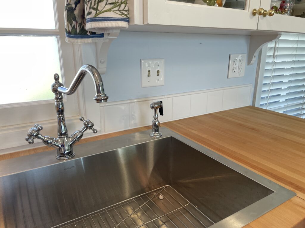 New single bowl stainless steel sink and faucet set. Low profile flange for top mounting since 30" cabinet base was previously modified to fit prior 33" double-bowl coated cast iron sink