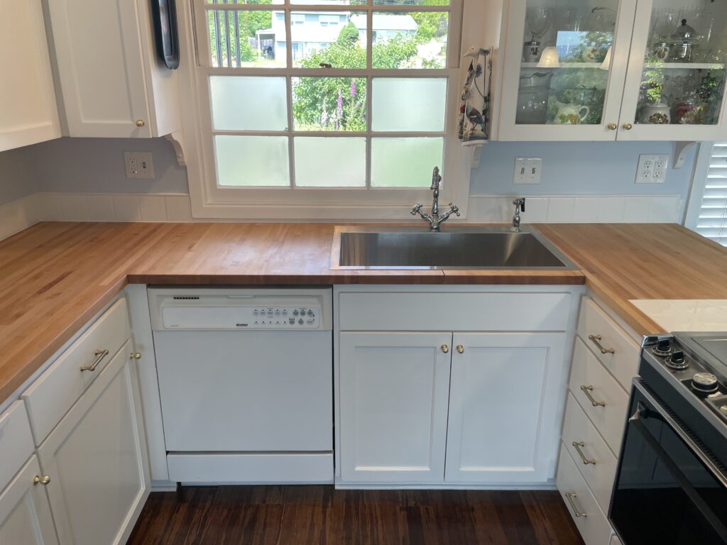 U-shaped kitchen with wood grain of butcher block countertops all parallel to avoid diagonal miter seams and cross grain seams by Action Craftworks LLC