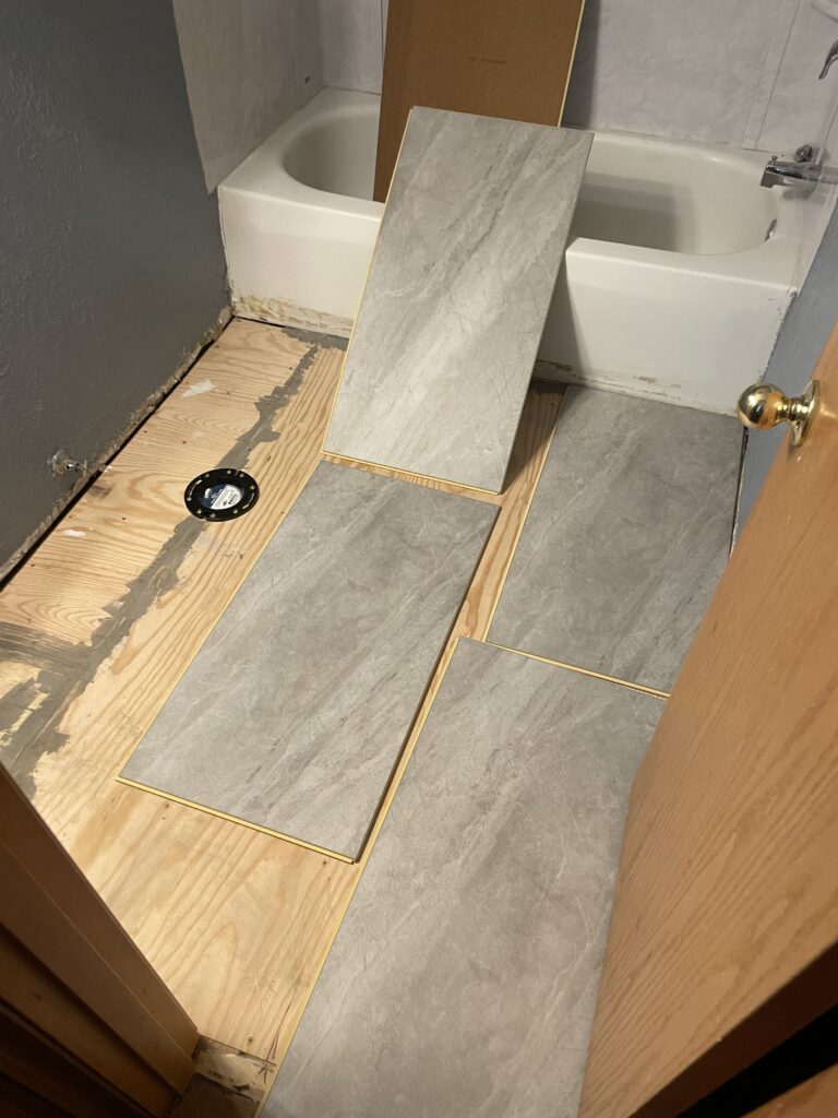 Bathroom renovation, test fitting vinyl plank flooring boards by Action Craftworks LLC in Vancouver, WA