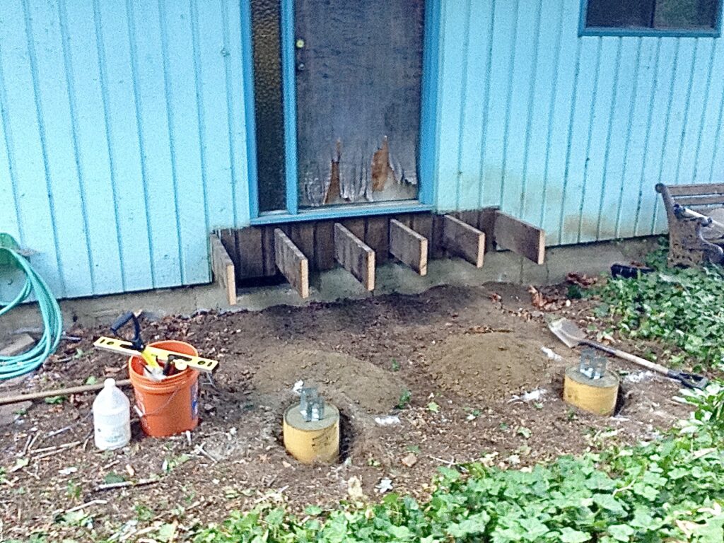 Existing joists cut back and concrete footings poured for porch deck rebuild by Action Craftworks LLC in Vancouver, WA