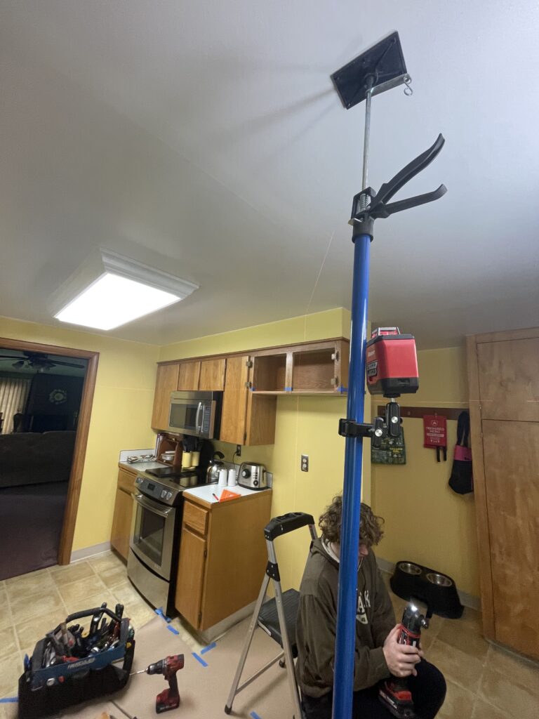 Kitchen cabinet renovation using a laser level to mark the cut line by Action Craftworks LLC in Vancouver, WA